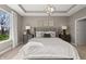 A well lit bedroom features neutral walls, a tray ceiling, and a comfortable king bed at 19357 Sumrall Pl, Westfield, IN 46074