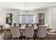 Spacious dining room with a large table set for eight, modern chandelier, and bright window lighting at 19357 Sumrall Pl, Westfield, IN 46074
