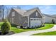 Rear of a charming two-story home featuring a well-maintained lawn and two-car garage at 19357 Sumrall Pl, Westfield, IN 46074