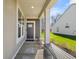 Inviting covered front porch with gray door, side panel, and sitting bench provides curb appeal at 19357 Sumrall Pl, Westfield, IN 46074