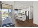 Modern white kitchen features stainless appliances, center island with bar stool seating, and hardwood floors at 19357 Sumrall Pl, Westfield, IN 46074
