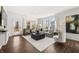 Bright living room features a comfortable gray sofa, wood floors, accent chairs, and natural light at 19357 Sumrall Pl, Westfield, IN 46074