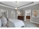 Spacious main bedroom featuring tray ceiling, stylish chandelier, and an ensuite bathroom at 19357 Sumrall Pl, Westfield, IN 46074