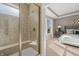 Walk-in shower with tile surround and glass door, complemented by a view into the bedroom with natural light at 19357 Sumrall Pl, Westfield, IN 46074