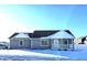 Gray house with white accents, covered front porch, and snow-covered yard at 2103 Twelve Oaks Dr, Shelbyville, IN 46176