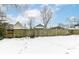 Snowy backyard with a wooden fence and neighboring houses at 2214 Pleasant St, Indianapolis, IN 46203