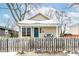 Charming bungalow with a blue door, porch swing, and fenced yard at 2214 Pleasant St, Indianapolis, IN 46203