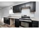 Modern kitchen with dark cabinetry, stainless steel appliances, and granite countertops at 2850 S Lockburn, Indianapolis, IN 46241