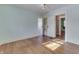 Bedroom with hardwood floors, built-in shelves, and access to other rooms at 3135 E Southport Rd, Indianapolis, IN 46227