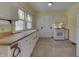 Kitchen with white cabinets, wood countertops, and tile floor at 3135 E Southport Rd, Indianapolis, IN 46227