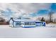 White house with blue accents, snow covered yard, detached garage and shed at 320 Peach Tree Ln, Indianapolis, IN 46219