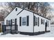 White house with black accents and snowy yard. Side view at 3501 Caroline Ave, Indianapolis, IN 46218