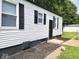 A side view of the home featuring white siding, black trim, and neat landscaping around the perimeter at 3501 Caroline Ave, Indianapolis, IN 46218