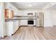 Kitchen boasts white cabinets, stainless steel appliances, and wood-look floors at 5334 Thrasher Dr, Indianapolis, IN 46254