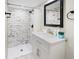 Updated bathroom with a white vanity and marble-look shower tiles at 714 Berkley Rd, Indianapolis, IN 46208