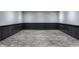 Empty basement room with dark gray wainscoting and wood-look floors at 11091 Crooked Stick Ln, Carmel, IN 46032