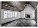 Gathering room with vaulted ceiling, stone fireplace, and dark tile flooring at 11091 Crooked Stick Ln, Carmel, IN 46032