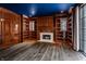 Elegant library with wood paneled walls, built in shelving and fireplace at 11091 Crooked Stick Ln, Carmel, IN 46032