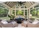 Cozy screened porch with wicker furniture and forest views at 11091 Crooked Stick Ln, Carmel, IN 46032