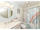 Bright bathroom featuring a tub and shower with a rainbow unicorn curtain, and round mirror at 14990 E 104Th St, Fishers, IN 46040