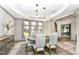 Elegant dining room with a round table, upholstered chairs, and large windows at 14990 E 104Th St, Fishers, IN 46040