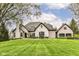 Beautiful two-story home featuring brick and stone exterior with a lush green lawn and manicured landscaping at 14990 E 104Th St, Fishers, IN 46040