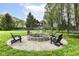 An inviting stone fire pit with Adirondack chairs, perfect for cozy outdoor gatherings at 14990 E 104Th St, Fishers, IN 46040