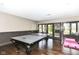 Spacious game room with a ping pong table, dark wood floors, and large glass doors to outside at 14990 E 104Th St, Fishers, IN 46040
