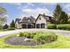 Spacious three-car garage with a circular driveway and landscaped flower bed at 14990 E 104Th St, Fishers, IN 46040