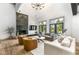 Spacious living room with a fireplace, large windows, hardwood floors, and comfortable seating at 14990 E 104Th St, Fishers, IN 46040