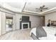 Primary bedroom with fireplace, wood-look flooring, patio access, and large windows at 14990 E 104Th St, Fishers, IN 46040
