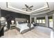 Large primary bedroom with wood-look flooring, ceiling fan, and modern tray ceiling at 14990 E 104Th St, Fishers, IN 46040