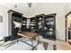 Home office featuring custom built-in bookcases and a desk with hardwood floors at 14990 E 104Th St, Fishers, IN 46040
