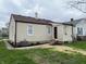 The home features a backyard with green grass and a stone path leading to the back door at 1612 E Raymond St, Indianapolis, IN 46203