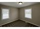 Cozy bedroom featuring neutral paint, carpet floors, and natural light from two windows at 1612 E Raymond St, Indianapolis, IN 46203