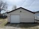 A close up of the detached one-car garage features white siding and door at 1612 E Raymond St, Indianapolis, IN 46203