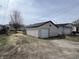 View of the detached one car garage with white siding and door at 1612 E Raymond St, Indianapolis, IN 46203