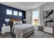 Bedroom with navy accent wall, large window, and hardwood floors at 3050 Vista View Dr, Greenwood, IN 46143
