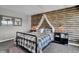 Cozy bedroom featuring a rustic log cabin wall and metal framed bed at 3050 Vista View Dr, Greenwood, IN 46143