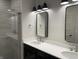 Bathroom with a double vanity, modern lighting, and tiled shower with glass door at 373 S Cherry St, Westfield, IN 46074