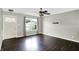 Bright living room features a large window with backyard views and dark hardwood floors, and modern ceiling fan at 5327 Milhouse Rd, Indianapolis, IN 46221