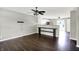 Open-concept living space with dark hardwood floors, modern grey paint, ceiling fan, and an adjacent kitchen area at 5327 Milhouse Rd, Indianapolis, IN 46221
