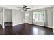 Inviting living room featuring a large window, hardwood floors, modern ceiling fan, and stylish grey paint at 5327 Milhouse Rd, Indianapolis, IN 46221