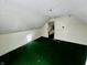 Another attic bedroom with green carpet and window at 1125 Laurel St, Indianapolis, IN 46203