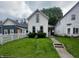 Charming two-story home with landscaped yard and inviting walkway to a cozy front porch at 1125 Laurel St, Indianapolis, IN 46203