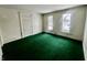 Living room with green carpet and two windows at 1125 Laurel St, Indianapolis, IN 46203