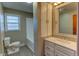 Bright bathroom features a window, white vanity with storage, mirror, and a toilet at 2010 N Irwin St, Indianapolis, IN 46219