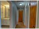 Hallway with hardwood floors leads to bathroom with white vanity and wood doors at 2010 N Irwin St, Indianapolis, IN 46219