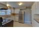 Well-lit kitchen with stainless steel refrigerator, white cabinets, and linoleum flooring at 2010 N Irwin St, Indianapolis, IN 46219