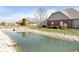 Backyard featuring a scenic pond with landscaped surroundings and well-maintained lawn at 2811 Grandview Ln, Greenwood, IN 46143